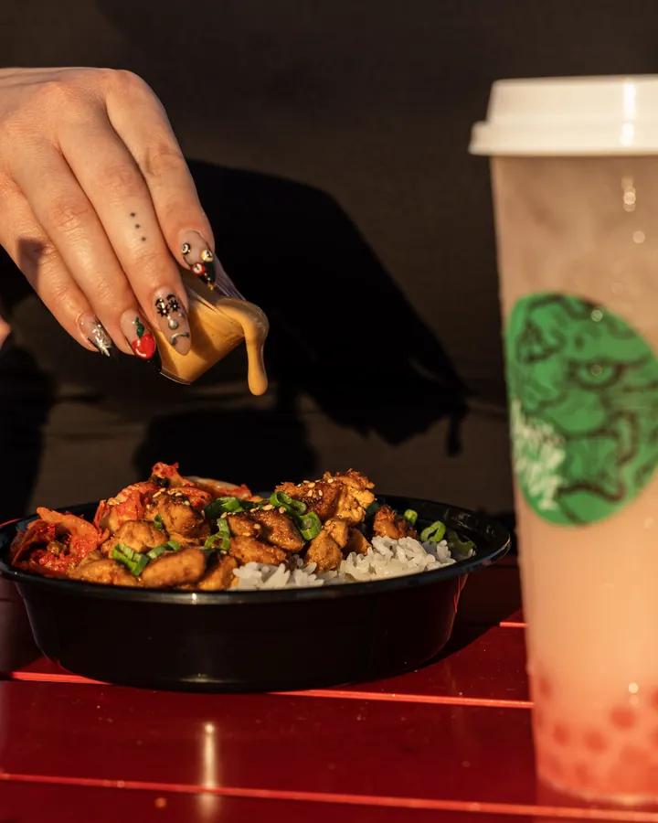 Sauce being poured on rice bowl at Dang Dude